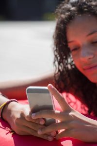 Ado sur son téléphone en plein air Addictions aux écrans : comment réduire le temps quotidien ?